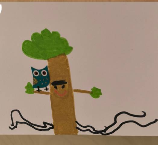 Dessin d’enfant : un arbre au visage souriant, avec un hibou